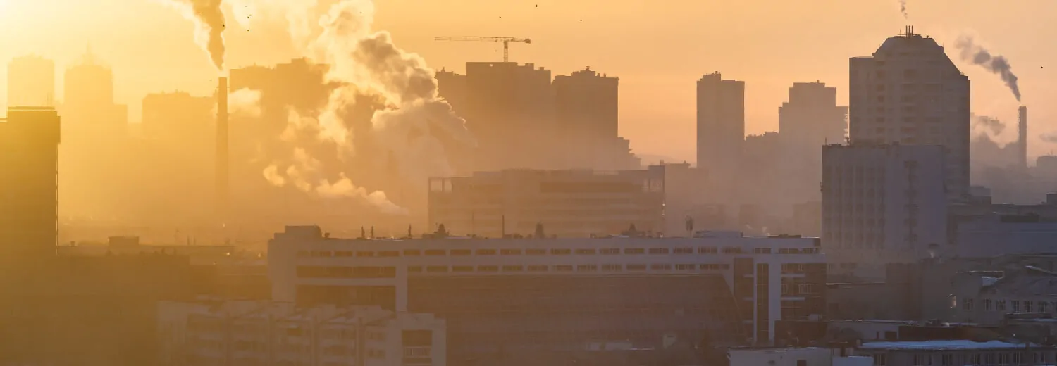 Amanhecer sobre a cidade. O sol ilumina a poluição sobre a cidade. -Consultoria Qualidade do Ar