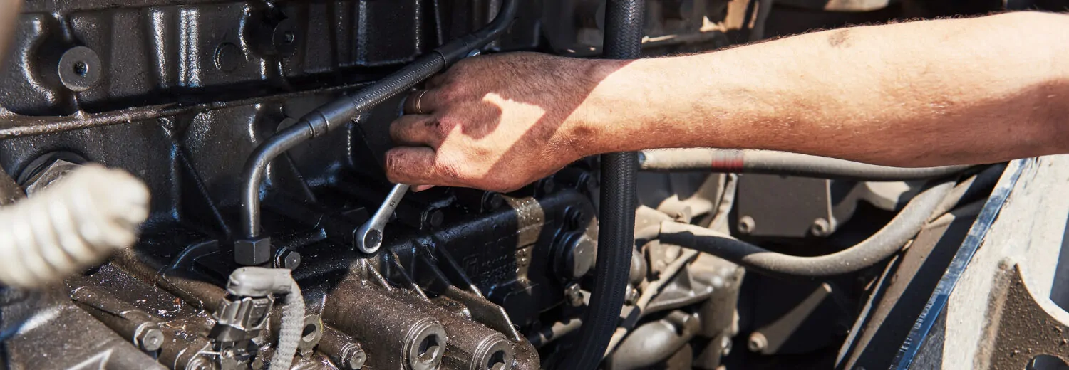 Ajuste de componentes em um motor a diesel pesado. A manutenção preventiva é essencial para aumentar a durabilidade do equipamento e evitar paradas inesperadas.