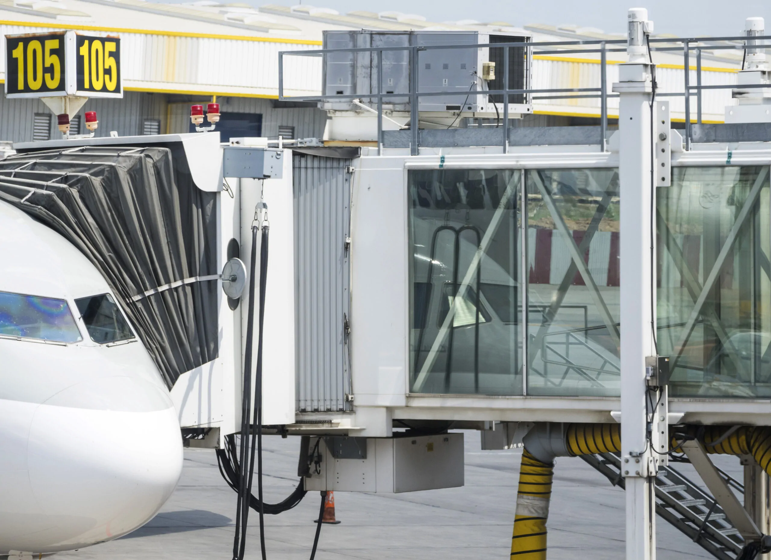 Manga de embarque telescópica conectada diretamente à porta da aeronave. Esse equipamento permite o acesso seguro e protegido dos passageiros, eliminando a exposição às condições climáticas e otimizando o fluxo de embarque e desembarque. - Curso Operador Mangas Embarque.