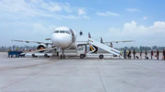 Processo de embarque realizado no pátio do aeroporto com o uso de escadas móveis, um método tradicional utilizado em operações onde mangas de embarque telescópicas não estão disponíveis ou viáveis, exigindo deslocamento externo dos passageiros entre o terminal e a aeronave. - Curso Operador Mangas Embarque.