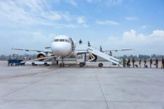 Processo de embarque realizado no pátio do aeroporto com o uso de escadas móveis, um método tradicional utilizado em operações onde mangas de embarque telescópicas não estão disponíveis ou viáveis, exigindo deslocamento externo dos passageiros entre o terminal e a aeronave. - Curso Operador Mangas Embarque.