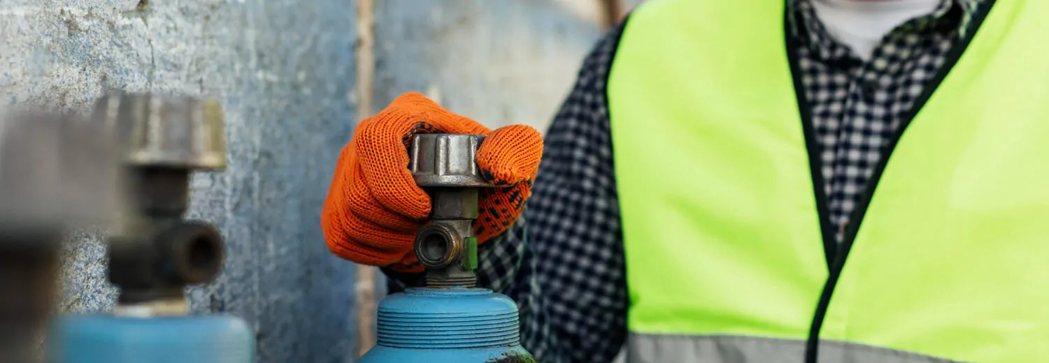 Trabalhador manuseando cilindros de gases industriais com EPIs adequados, reforçando a importância das práticas seguras no manuseio - Curso Cilindro Gases Industriais.