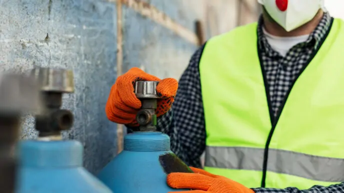 Trabalhador manuseando cilindros de gases industriais com EPIs adequados, reforçando a importância das práticas seguras no manuseio - Curso Cilindro Gases Industriais.