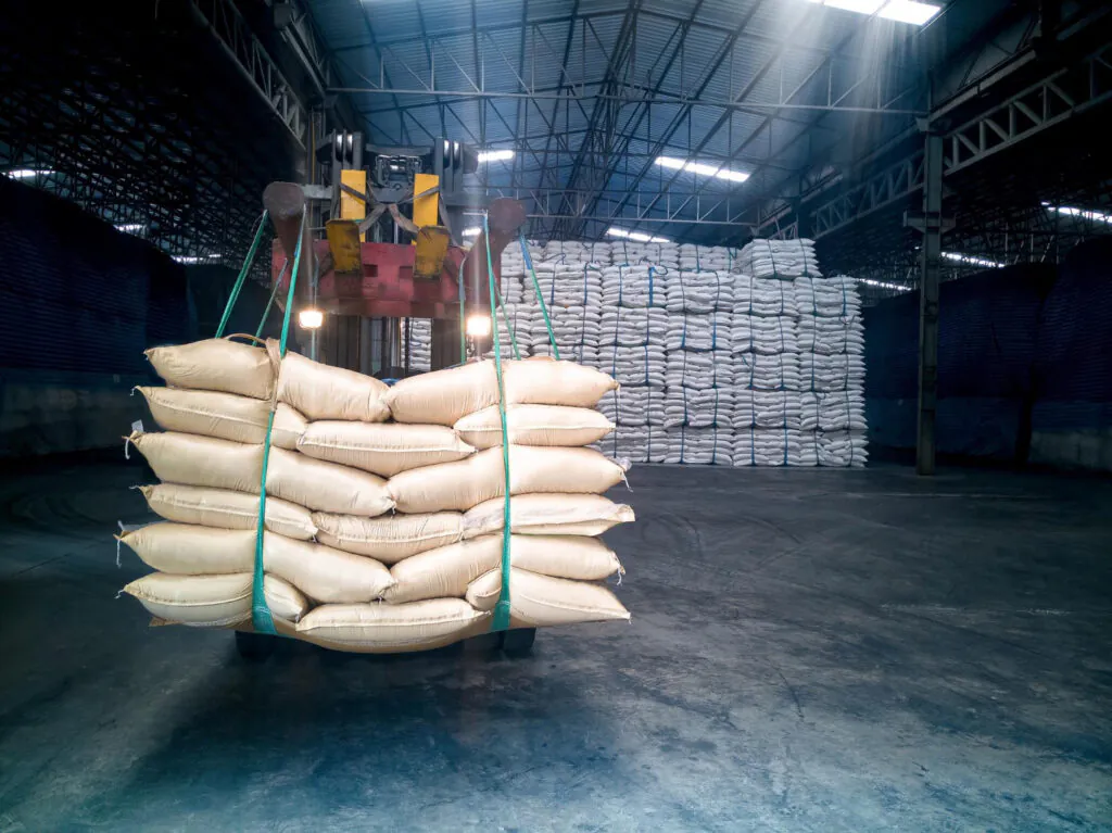 operação de movimentação de carga com empilhadeira em ambiente industrial, mais especificamente em um armazém ou galpão de estocagem - Curso Laudo Movimentação Cargas