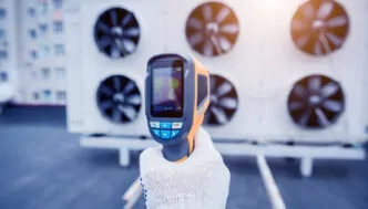 O técnico usa um termômetro infravermelho de imagem térmica para verificar o trocador de calor da unidade de condensação. - Consultoria Implantação Plano Higienização e PGR Refrigeração