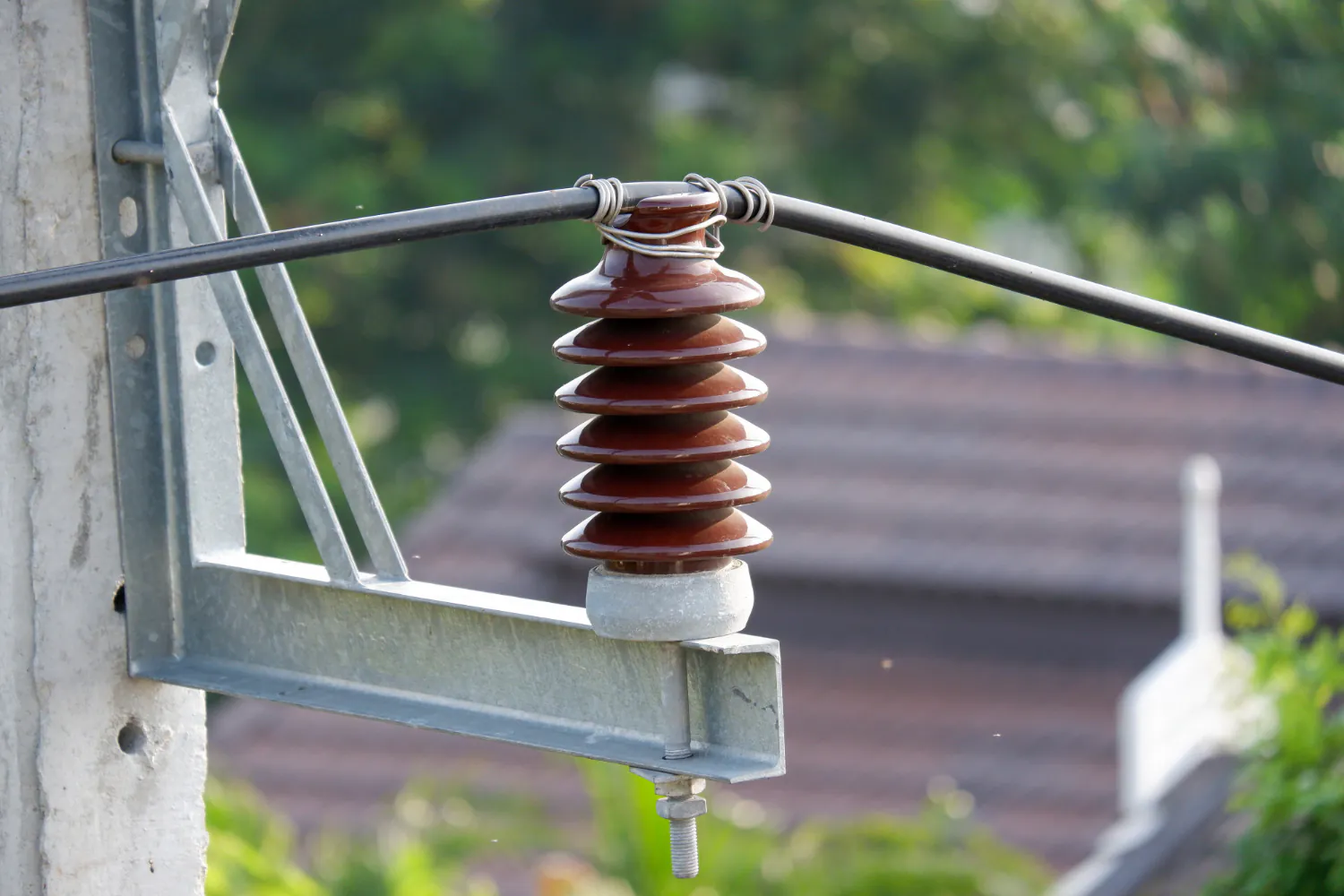  Isolador pino instalado em estrutura metálica de média tensão. Avaliação visual e integridade dielétrica essenciais no laudo técnico. Trincas, fissuras ou contaminação superficial comprometem a isolação.