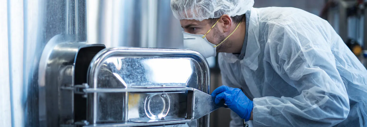 Inspeção técnica de equipamento industrial em aço inoxidável, etapa crítica para garantir a integridade da camada passiva e evitar falhas por contaminação ou corrosão em processos farmacêuticos ou biomédicos.