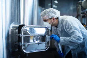 Inspeção técnica de equipamento industrial em aço inoxidável, etapa crítica para garantir a integridade da camada passiva e evitar falhas por contaminação ou corrosão em processos farmacêuticos ou biomédicos.