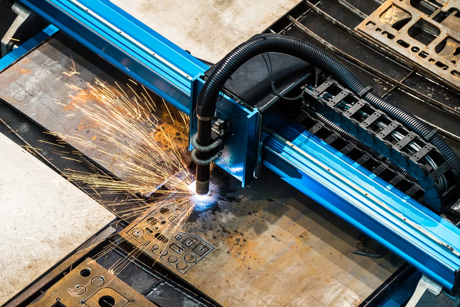 Sistema automatizado de corte por plasma executando recortes detalhados em chapas de aço. Alta eficiência com controle computadorizado e baixa deformação térmica. - Curso Corte por Plasma.
