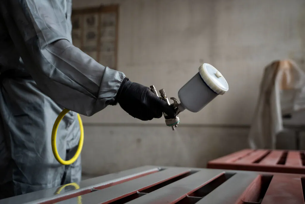 Aplicação de tinta epóxi condutiva em estrutura metálica com pistola airless: controle da espessura, ancoragem da superfície e condutividade são essenciais para garantir desempenho eletrostático em áreas classificadas.