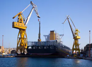 Guindastes com aplicação portuária para apoio logístico em atividades de carga e descarga de navios. Apesar de não estarem embarcados, seguem princípios similares aos guindastes offshore quanto à estabilidade, capacidade de carga e segurança operacional.