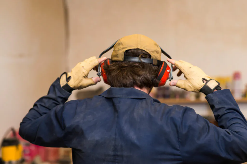 O uso correto de protetores auriculares tipo concha é essencial em ambientes industriais para reduzir a exposição a ruídos elevados e proteger a integridade auditiva dos trabalhadores.