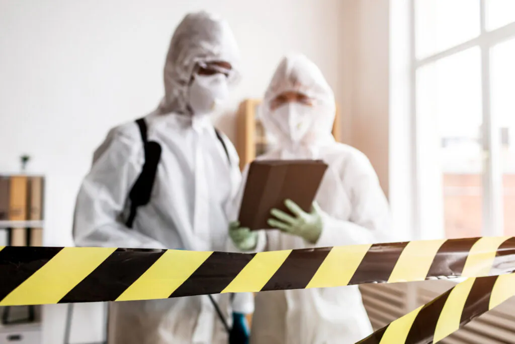 Profissionais com EPI em área isolada: Equipe técnica realiza avaliação de risco em ambiente controlado, utilizando vestimentas de proteção química e respiratória. - Treinamento Para Membros da CIPA ou Designado.