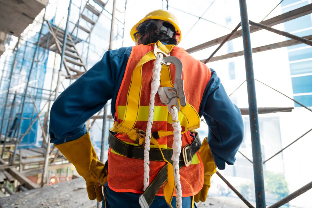 Trabalhador com sistema de proteção contra quedas: Operador em altura equipado com cinturão de segurança tipo paraquedista, talabarte com absorvedor de energia e trava-quedas. - Treinamento Para Membros da CIPA ou Designado.